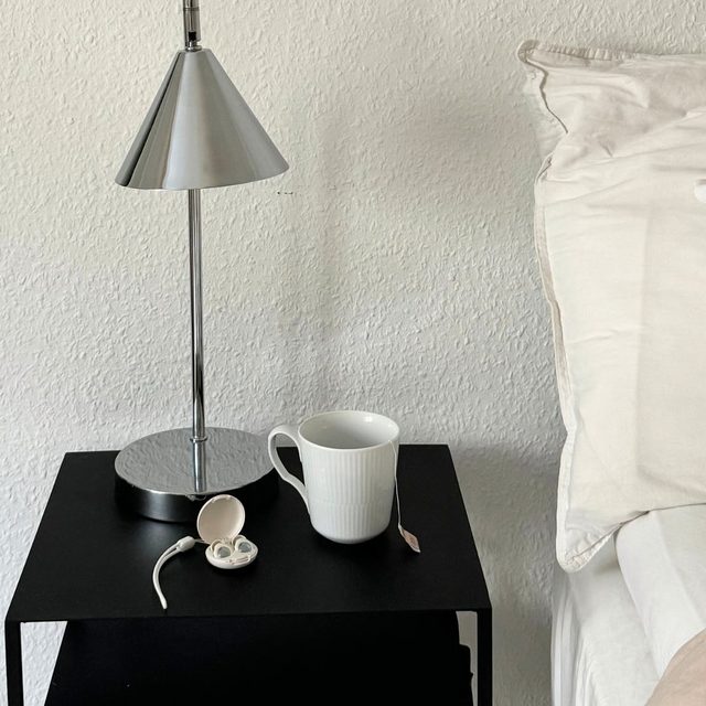 Lampe, tasse et boîtier sur la table de nuit